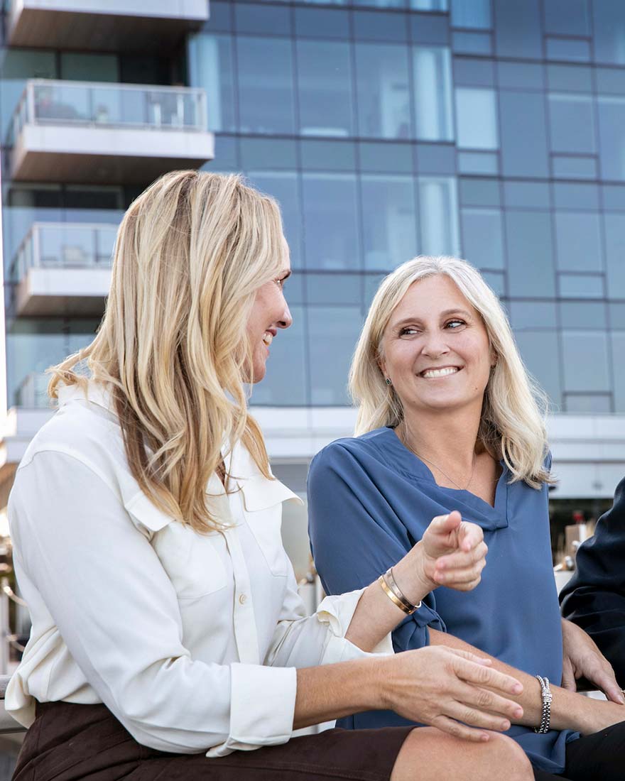 Kati-and-Michelle-Smiling-Talking-City-Background-880x1100